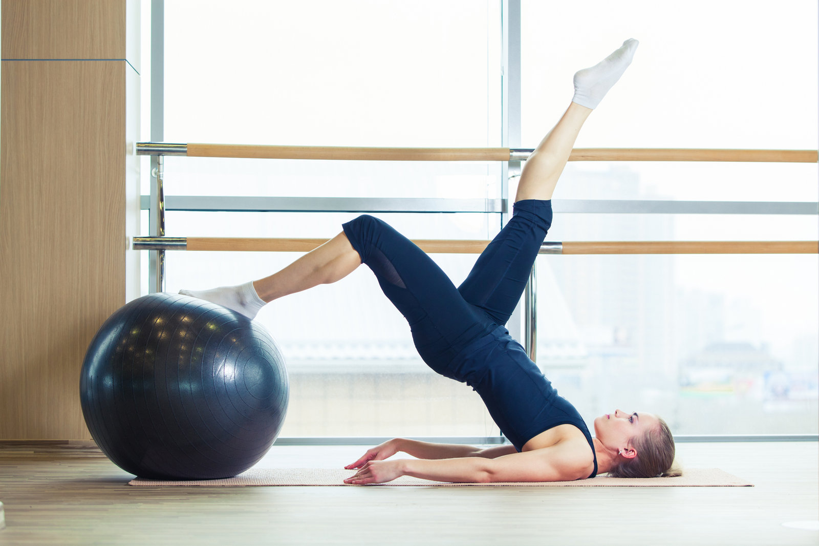 Photographie d’illustration : pratique du Pilates avec un ballon dans un studio
